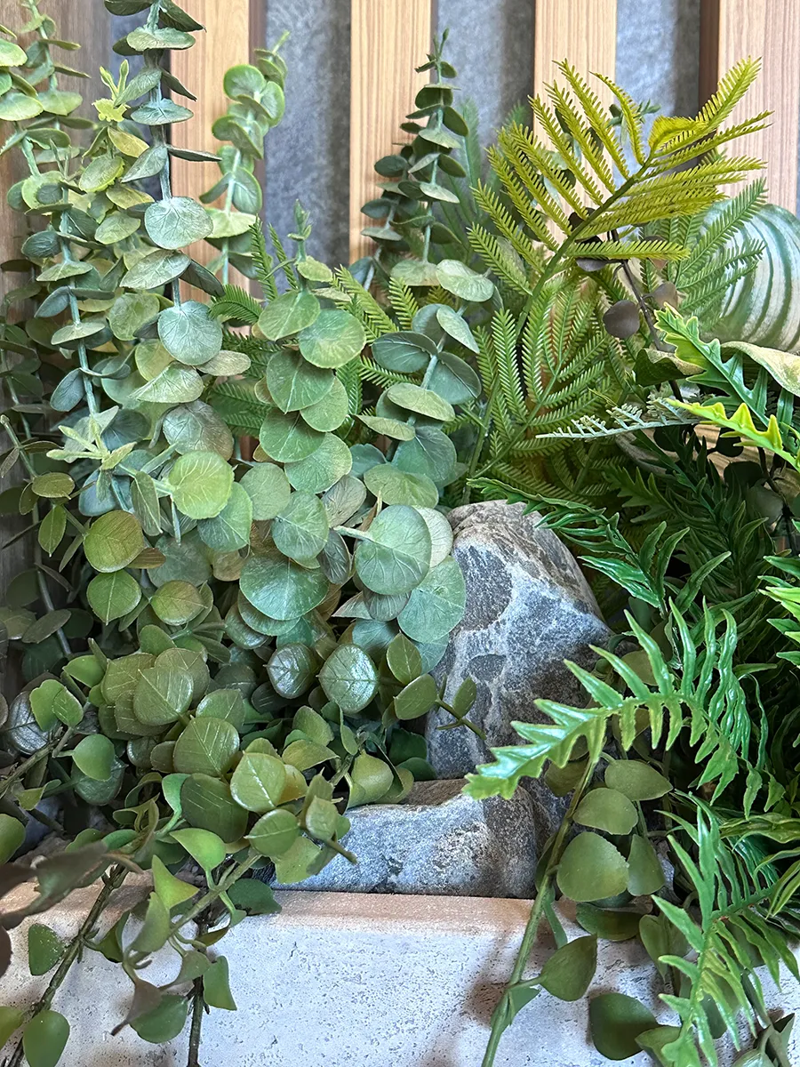 Озеленение парадных в доме искусственными растениями в бетонных кашпо.